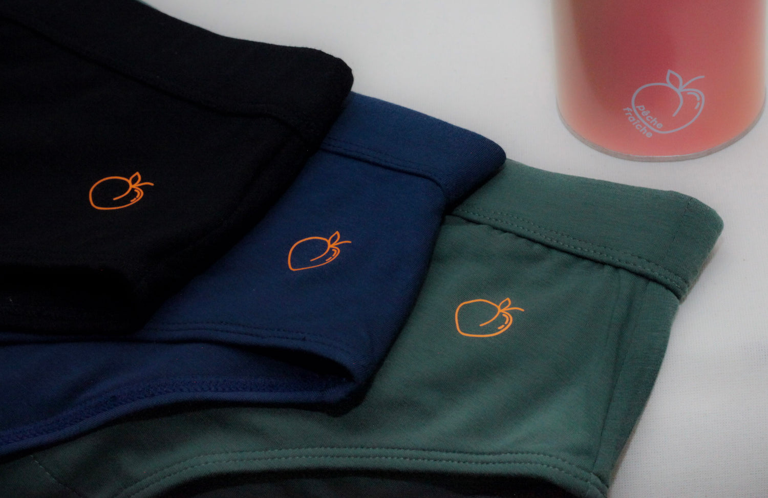 Three sustainable and soft briefs lie together in 3 colours with packaging. 